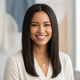 A smiling woman in her late 20s with straight, styled hair, looking confidently at the camera.